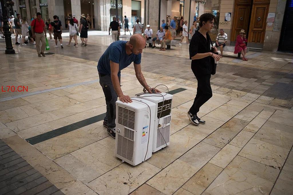 6月27日，欧洲多地气温超过40摄氏度。图为西班牙一名男子在搬运空调。（视觉中国）